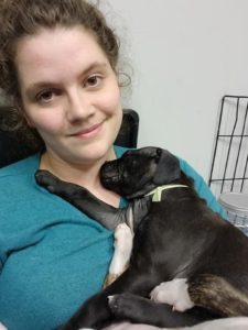 Volunteer, Becky Smith with pup in nursery.